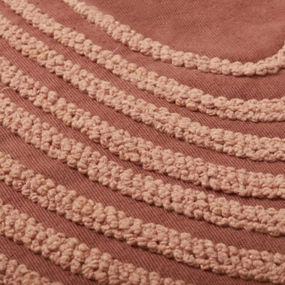 Blush cotton throw pillow with corner tassels, styled view