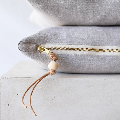 Oatmeal gray linen pillow with brass zipper, close-up