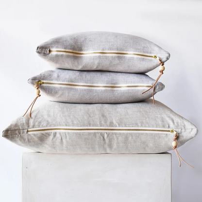 Oatmeal gray linen pillow with brass zipper, in a room setting